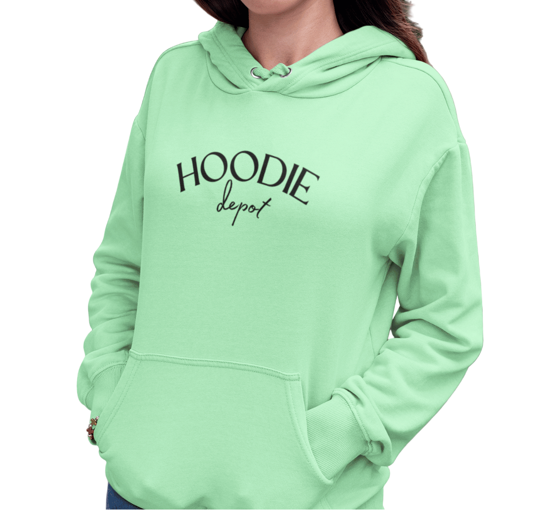 Woman wearing a light green hoodie with 'Hoodie Depot' text, standing outdoors.