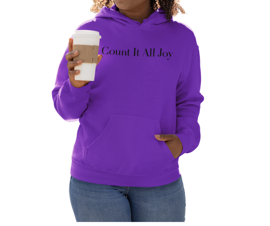 Person wearing a purple hoodie with 'Count It All Joy' text, holding a coffee cup.
